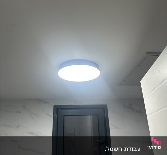 תאורה עגולה מותקנת על תקרה בחדר אמבטיה